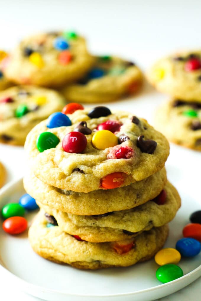 pile of finished chocolate chip m&m cookies on a white plate