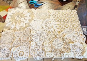 Arranging doilies on a large canvas to make doily wall art.