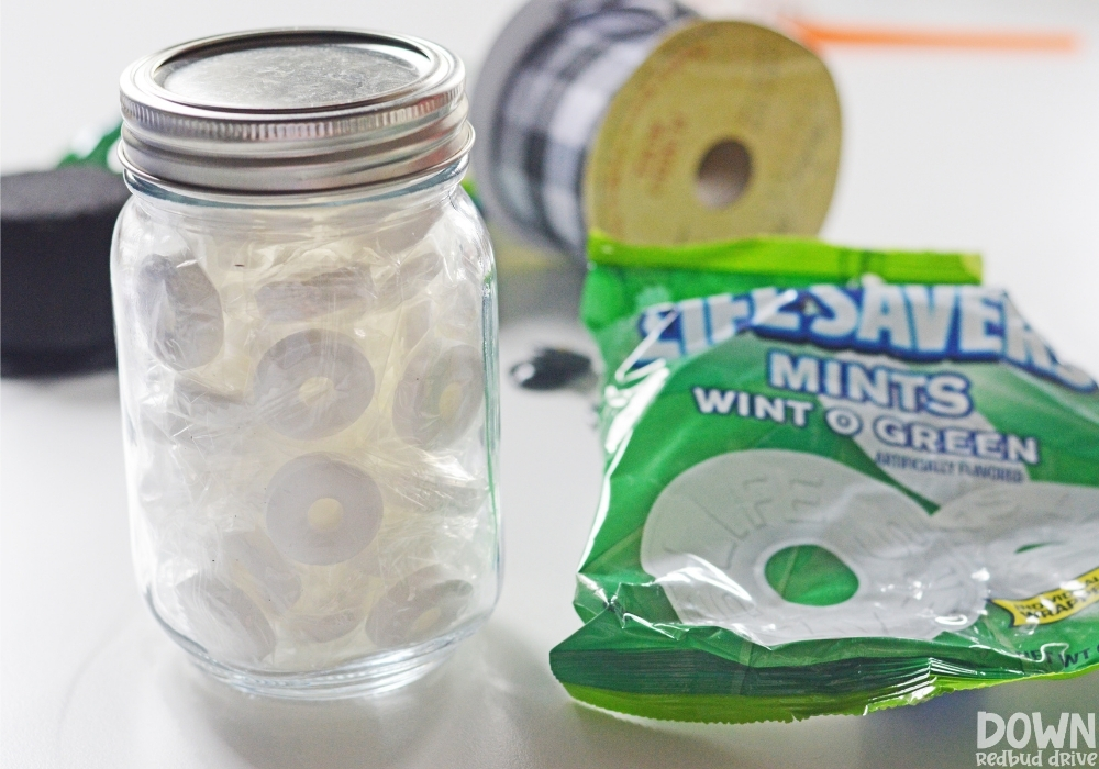 A mason jar filled with lifesaver mints.