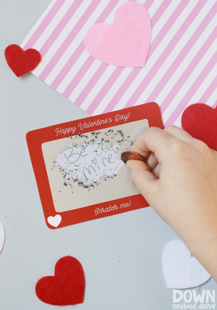 A tall closeup of a Scratch Off Valentine that says "Be mine!"