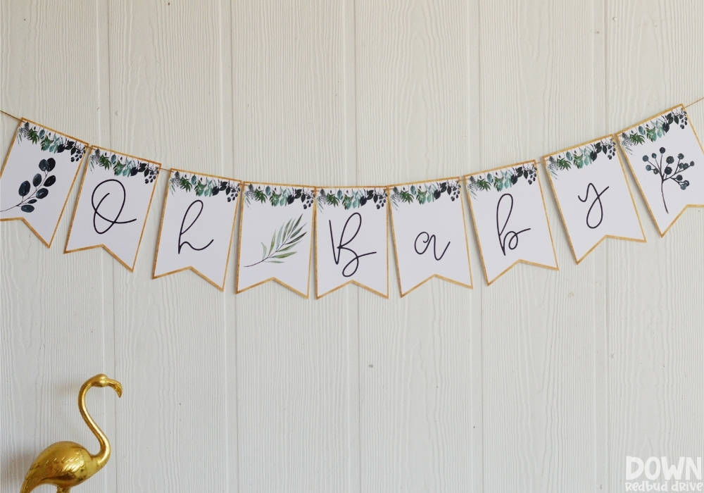 A greenery themed party banner that says "Oh Baby".
