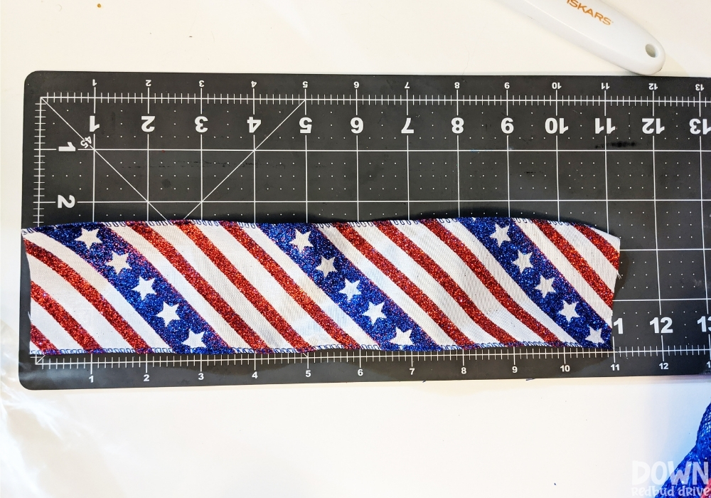 Patriotic ribbon cut to size on a rotary cutting mat.