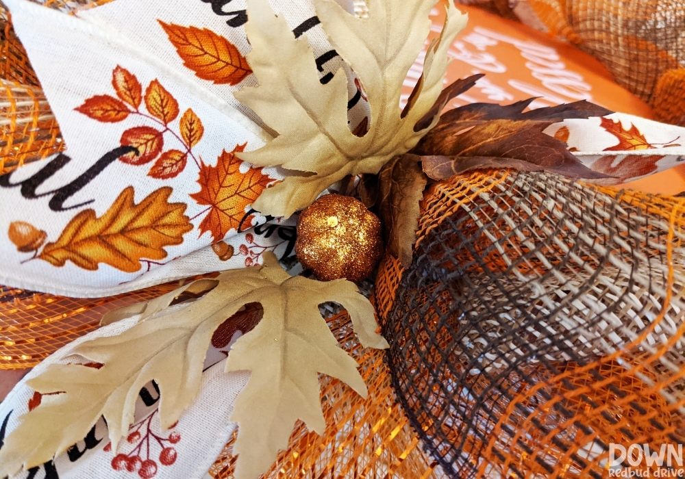 Closeup of an orange glitter mini pumpkin attached to the fall deco mesh wreath.