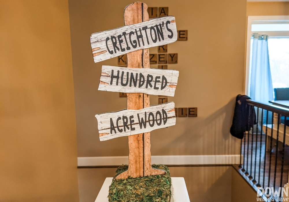 A sign that says "Creighton's Hundred Acre Wood" for a Winnie The Pooh Birthday Party.
