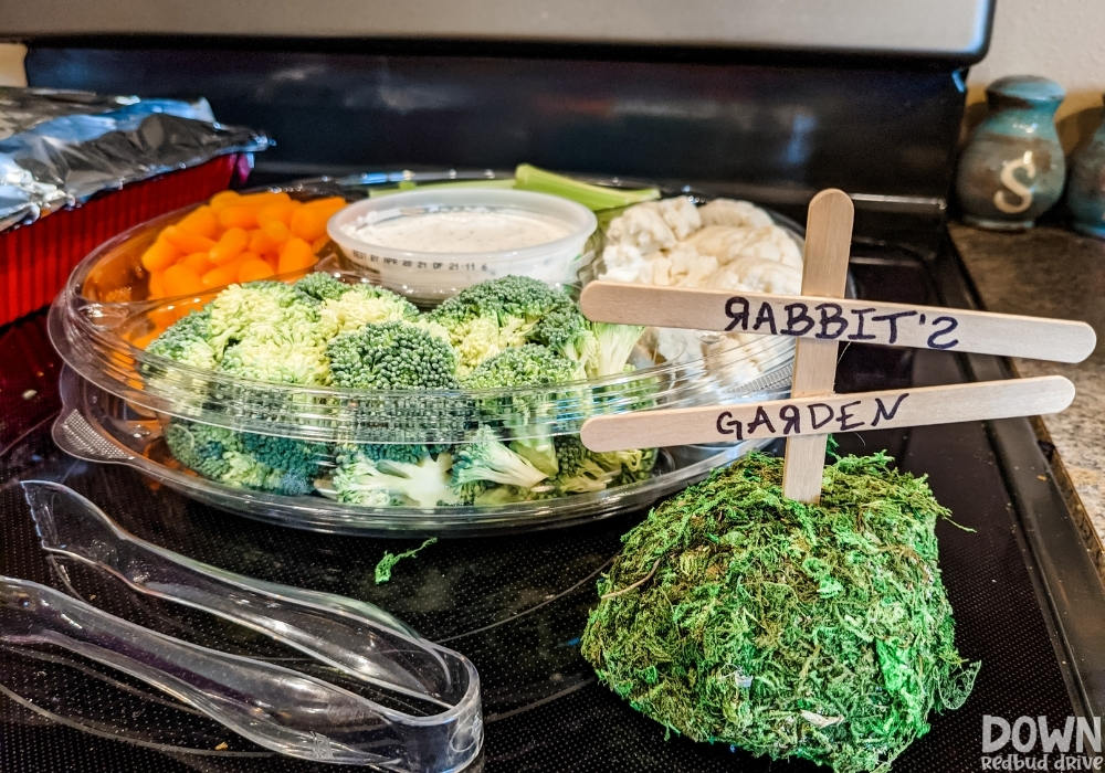 A Winnie The Pooh themed vegetable tray with a sign that says "Rabbit's Garden".