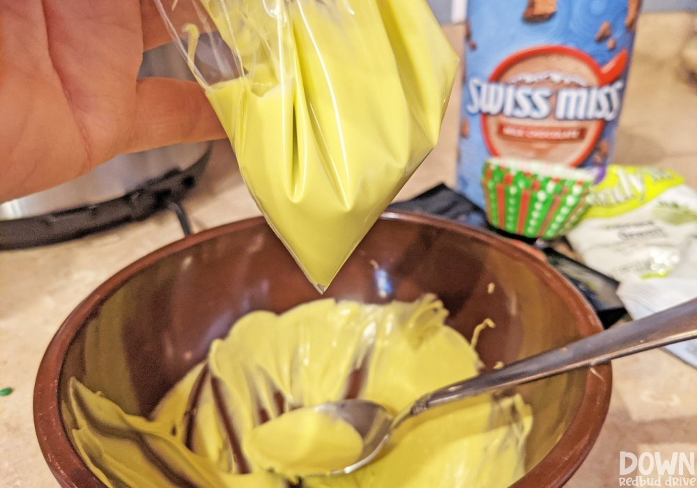 Yellow chocolate being added to a piping bag for decorating the finished hot chocolate bombs.