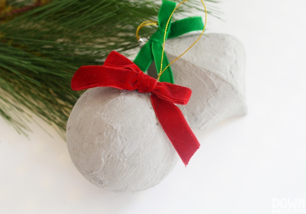 The finished concrete Christmas ornaments with red and green velvet bows.