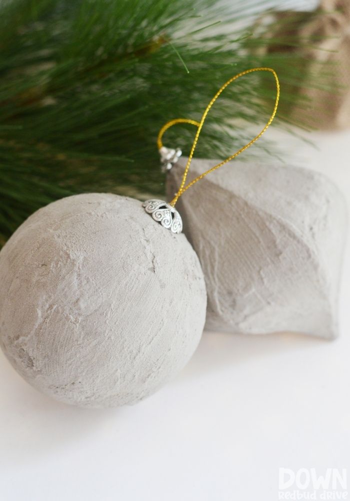 A tall closeup of the finished DIY Concrete Christmas Ornaments.