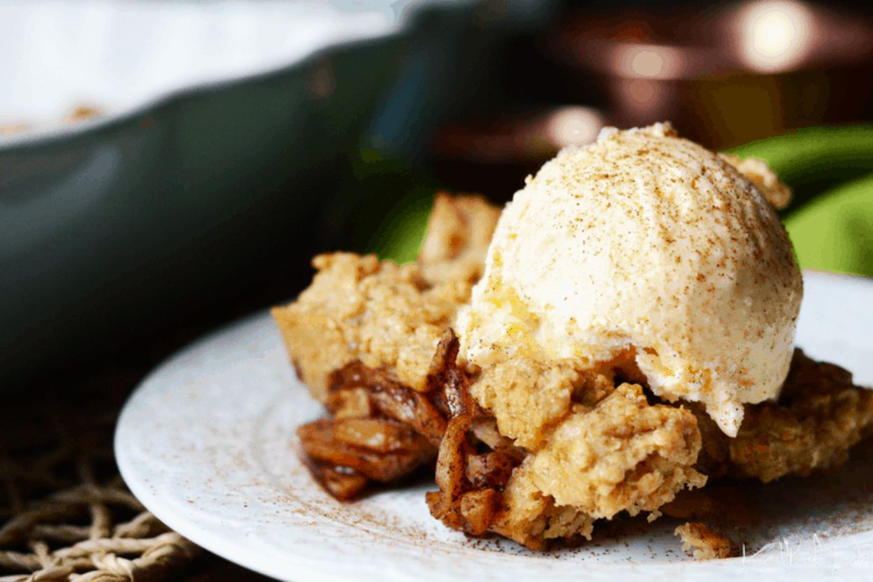 Homemade zucchini crisp topped with a scoop of vanilla ice cream