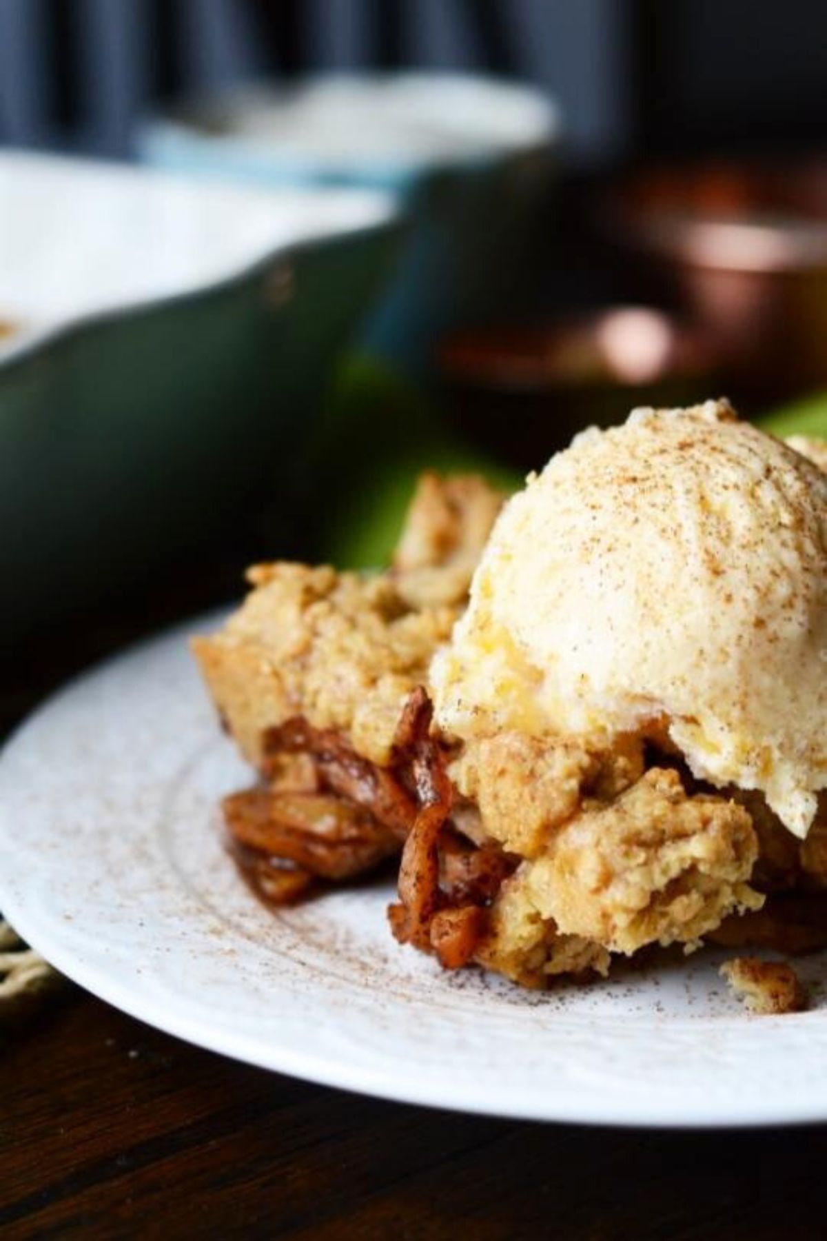 Homemade zucchini crisp topped with a scoop of vanilla ice cream