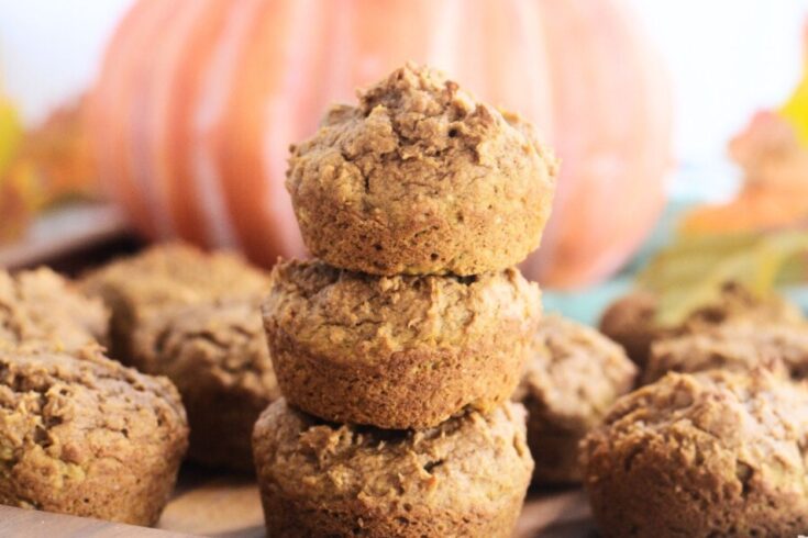a stack of 3 pumpkin muffins on a wooden serving tray