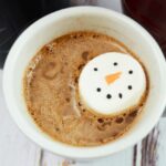 1 cup of hot chocolate with snowman marshmallows in it.