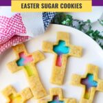 finished stained glass sugar cookies in the shape of crosses with a candy center of various colors with a text overlay that says stained glass cross cookies easter sugar cookies