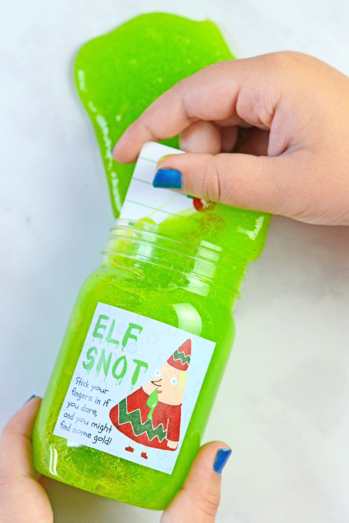A close up of a jar of finished elf snot with a gift card being pulled out of the snot