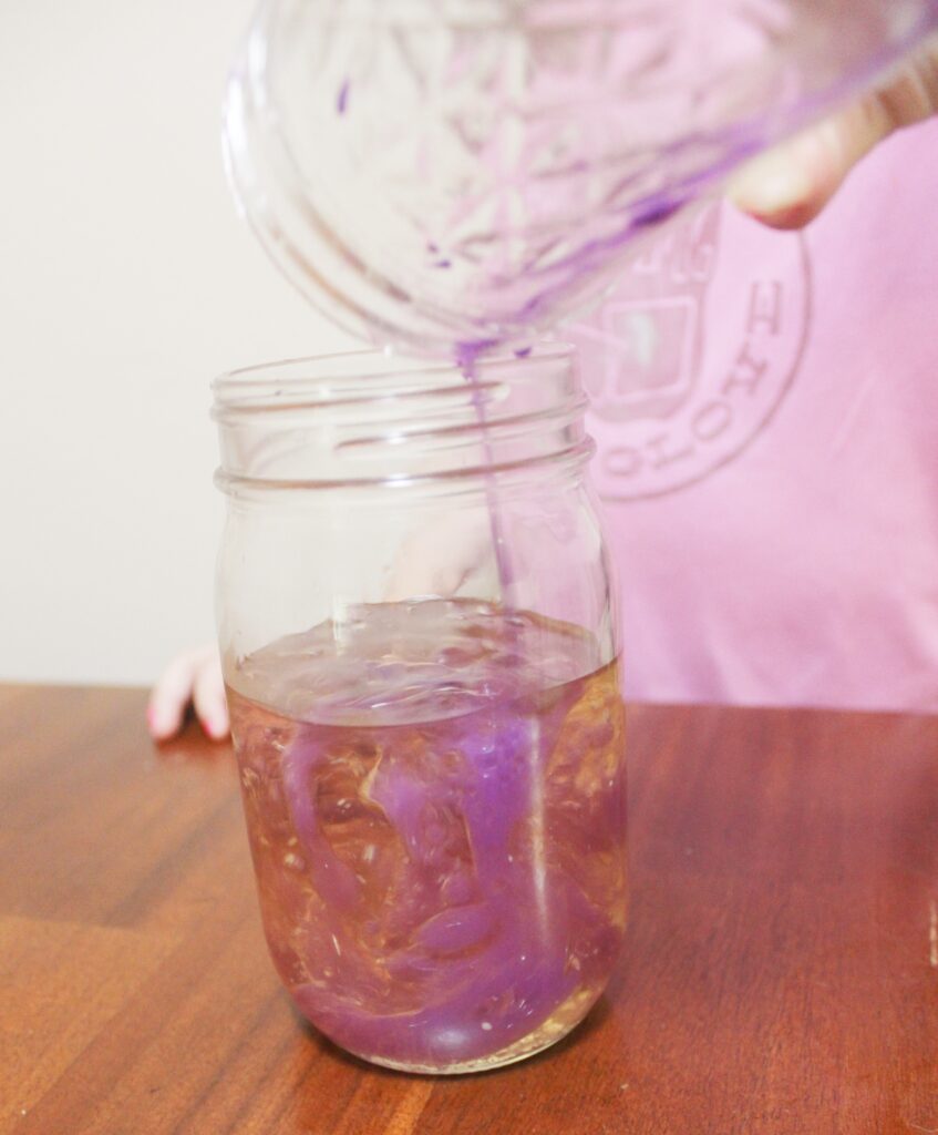 pouring paint and water mixture into oil 